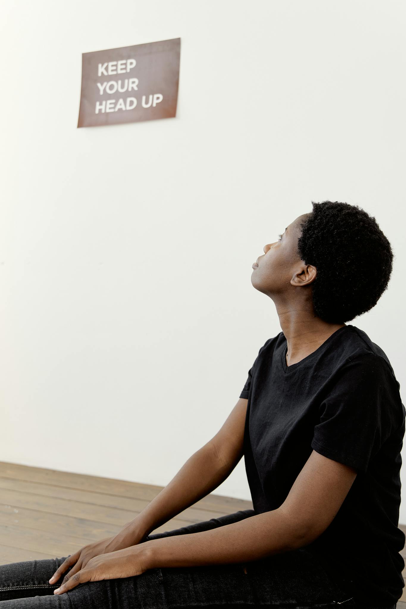 A young woman looking up at an inspiring message on the wall.