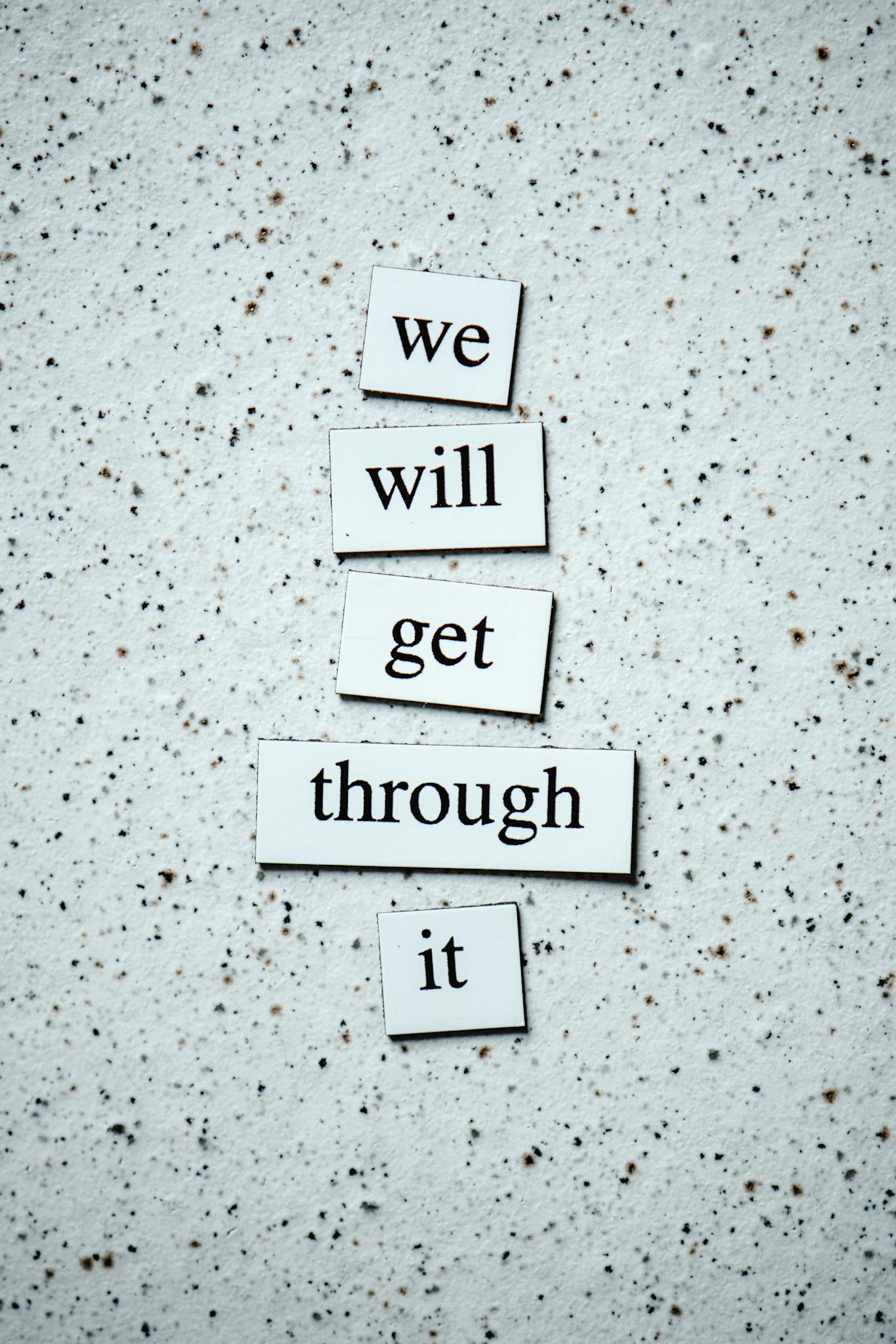 Motivational message "we will get through it" on a textured background for encouragement.